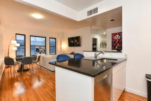 a kitchen and living room with a counter and a dining room at Elegant FiDi 3BR Condo - Private Elevator - Modern Luxury in New York