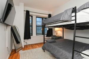 a bedroom with two bunk beds and a flat screen tv at Elegant FiDi 3BR Condo - Private Elevator - Modern Luxury in New York