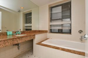 a bathroom with a tub and a sink and a window at Elegant FiDi 3BR Condo - Private Elevator - Modern Luxury in New York