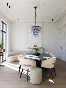 a dining room with a table and chairs and a chandelier at Statig herenhuis met grote tuin en jacuzzi in Geetbets +63 photos