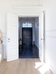 a hallway with a black door and a window at Statig herenhuis met grote tuin en jacuzzi in Geetbets