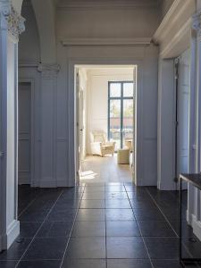 a hallway with a living room with a couch at Statig herenhuis met grote tuin en jacuzzi in Geetbets