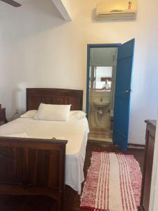 a bedroom with a bed and a bathroom with a toilet at Pousada santa rita in Paraty +6 photos