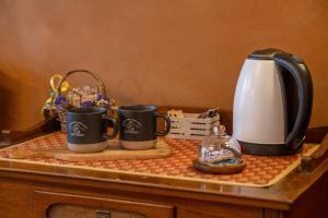 three coffee mugs on a table with a coffee maker at Ristoro la Crosetta in Caneva