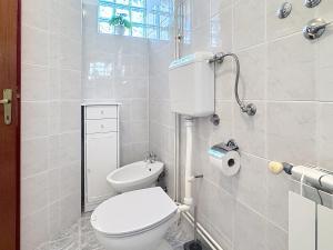 a white bathroom with a toilet and a window at Apartments Grozdana in Baška +49 photos