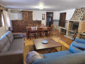 a living room with blue couches and a fireplace at El encinar de las nieves - Piscina privada, cerca de Toledo y Puy du Fou in Toledo