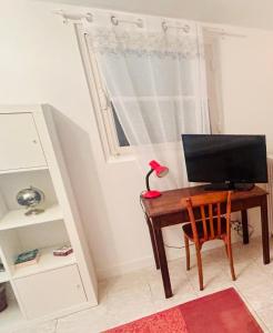 a desk with a computer and a red lamp on it at Beaurivage, studio privé dans maison d'hôte avec parc in Libourne
