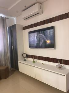 a living room with a tv on the wall at Apto familiar, 150mts do mar, completo e aconchegante em Palmas in Governador Celso Ramos +26 photos