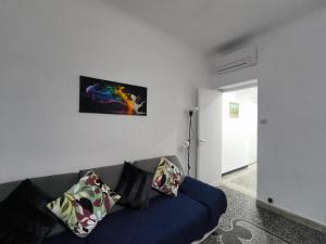 a living room with a blue couch and a painting on the wall at Casa Giorgia with Parking Space in Genoa