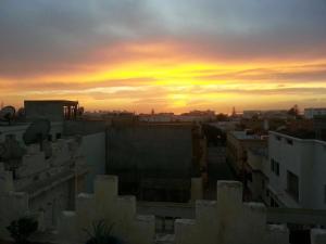 - une vue sur le coucher de soleil depuis le toit d'un bâtiment dans l'établissement Chez Fouzia, à Essaouira