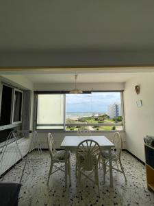 a dining room with a table and chairs and a window at Residence Port Saint Ange in Le Barcarès