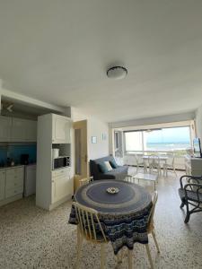 a kitchen and a living room with a table in a room at Residence Port Saint Ange in Le Barcarès