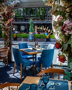 eine Terrasse mit Tischen und Stühlen in einem Restaurant in der Unterkunft Les Fleurs Boutique Hotel in Sofia