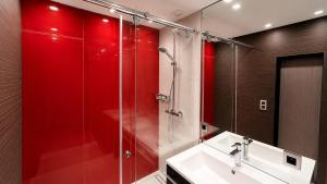 a bathroom with red walls and a sink and a shower at Antwerp Design Stay with Panoramic River Views in Antwerp +8 photos