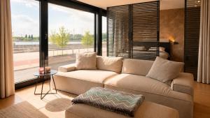 a living room with a couch and a large window at Antwerp Design Stay with Panoramic River Views in Antwerp