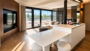 a kitchen with a white island in a living room at Antwerp Design Stay with Panoramic River Views in Antwerp