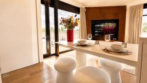 a dining room with a white table and chairs at Antwerp Design Stay with Panoramic River Views in Antwerp