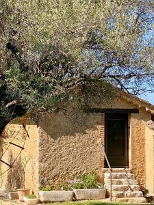 a small brick house with a door and stairs at La chambre du Mazet in Fayence