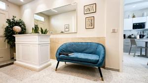 a blue chair in a living room with a mirror at R&B Dimora Teodorico in Ravenna