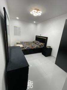 a bedroom with a bed in a white room at Garden Villa 4, Ajman in Ajman 