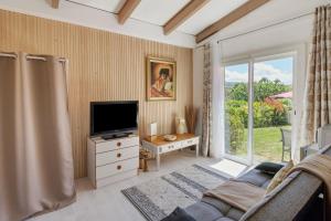 a living room with a tv and a couch at Le Pape - Chambre in Porticcio