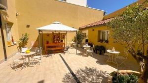 a patio with tables and chairs and a white umbrella at R&B Dimora Teodorico in Ravenna