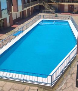 a large swimming pool with blue water at SIERRAS TRAVEL 2f in Villa Carlos Paz
