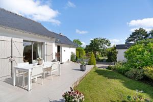 a patio with a table and chairs in a yard at Rêves d'Emeraude in Cancale