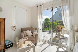 a living room with a chair and a large window at Rêves d'Emeraude in Cancale