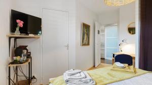 a bedroom with a bed and a tv and a desk at Chambre calme avec petit déjeuner in Gévezé