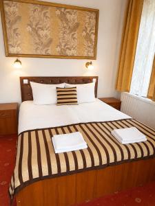 a bedroom with a large bed with two towels on it at Pałacyk in Międzywodzie