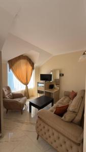 a living room with two couches and a table at Hotel Lazuri in Kvariati +19 photos