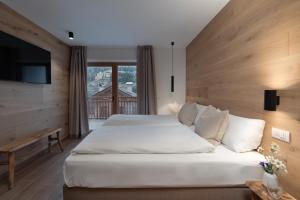 a bedroom with a large bed and a television at Residence Stella Alpina in Santa Cristina Gherdëina