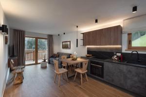 a kitchen and living room with a table and chairs at Residence Stella Alpina in Santa Cristina Gherdëina