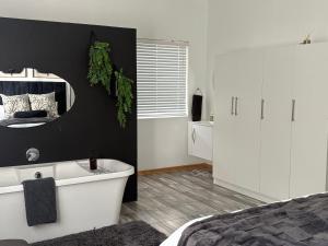 a bedroom with a bed and a mirror and a tub at ikibiki in Beaufort West +45 photos