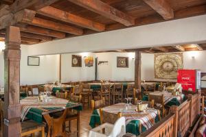 a restaurant with tables and chairs in a room at Хотелски комплекс Усоето in Elena