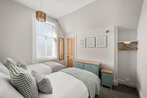 a bedroom with two beds and a window at Heywood Cottage in St. Andrews