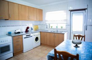 a kitchen with a sink and a dishwasher and a table at Villa BelaVista with Private Pool in Ferragudo