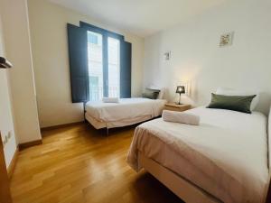 a bedroom with two beds and a large window at Two bedroom apartment behind the Rambla in Girona