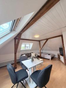 a room with a table and chairs in a attic at Top-floor apartment for up to 3 guests in Dreieich