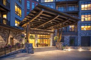 a large building with a wooden pergola at Avon Resort 2BR Suite in Avon