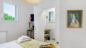 a white room with a bed and a painting on the wall at Chambre calme avec petit déjeuner in Gévezé +17 photos