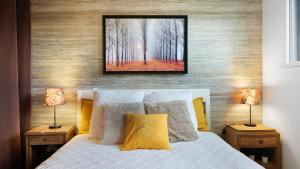 a bedroom with a bed with two lamps and a picture on the wall at Chambre calme avec petit déjeuner in Gévezé