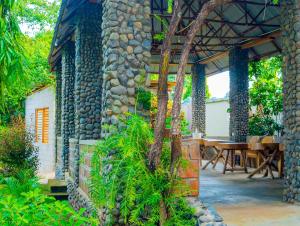 an outdoor patio with a table and a stone building at Breezy Lodge in Moshi