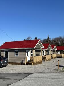 eine Häuserreihe mit roten Dächern auf einem Parkplatz in der Unterkunft Gros Morne Tiny Chalets in Rocky Harbour