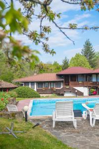 a swimming pool with two chairs and a house at Хотелски комплекс Усоето in Elena