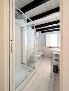 a bathroom with a glass shower and a toilet at The Superhost - The Loft in Crotone +13 photos