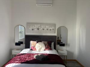 a bedroom with a large bed with two mirrors at ikibiki in Beaufort West