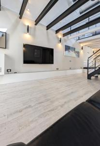 a large room with a flat screen tv on a wall at The Superhost - The Loft in Crotone
