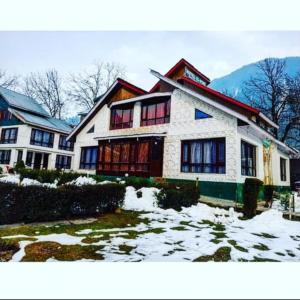 a large house with snow on the ground at Hotel alpine resort pahalgam in Pahalgām